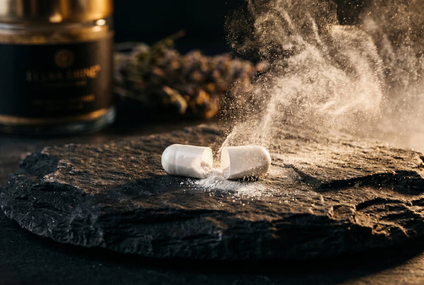 Magnesium capsule releasing white powder on dark stone — enhanced absorption with BioPerine in PURETREX Magnesium Glycinate Complex