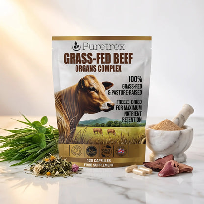 Puretrex Grass-Fed Beef Organs Complex food supplement pouch displayed on a marble surface with a cow illustration, herbs, capsules, and a marble mortar and pestle.