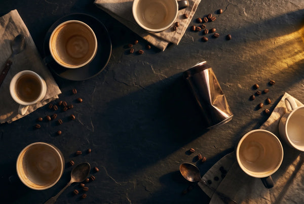 Empty coffee cups and scattered beans on dark surface — natural energy support with PURETREX Shilajit Sea Moss supplement