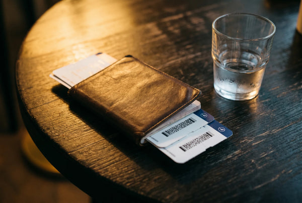 Travel passport and water glass on wooden table representing post-travel herbal digestive wellness routine