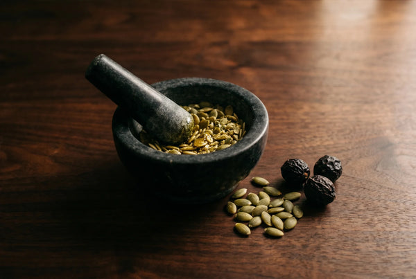 Stone mortar with crushed pumpkin seeds and saw palmetto berries representing botanical alternative to biotin and collagen supplements