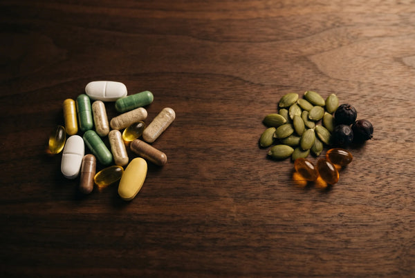 Pumpkin seed oil softgels with raw pumpkin seeds on dark wood showing clean two-ingredient transparent formula