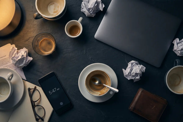 Multiple empty coffee cups on a dark desk — tiredness and fatigue support with PURETREX Magnesium Glycinate